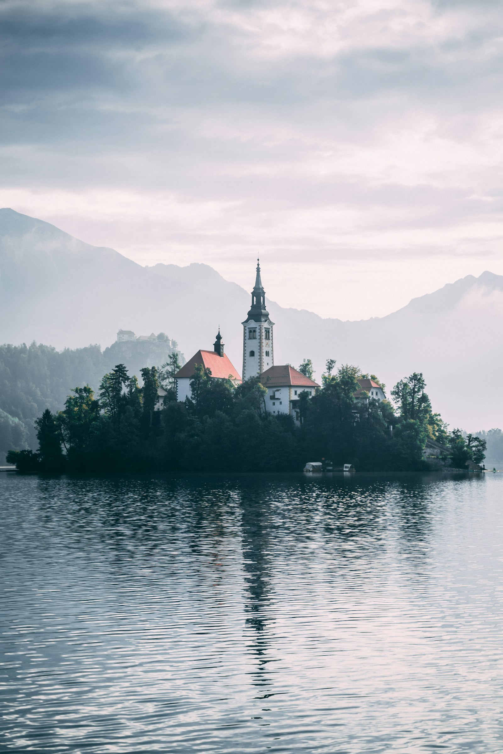The island church on Lake Bled with a clifftop castle and Alps beyond