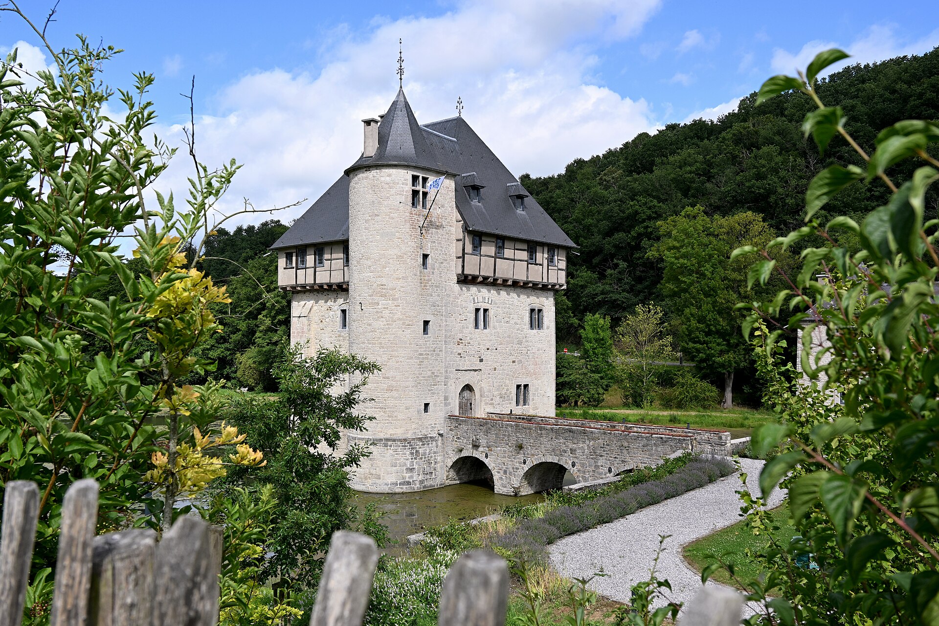 The moated medieval tower-house of Crupet rising from the water