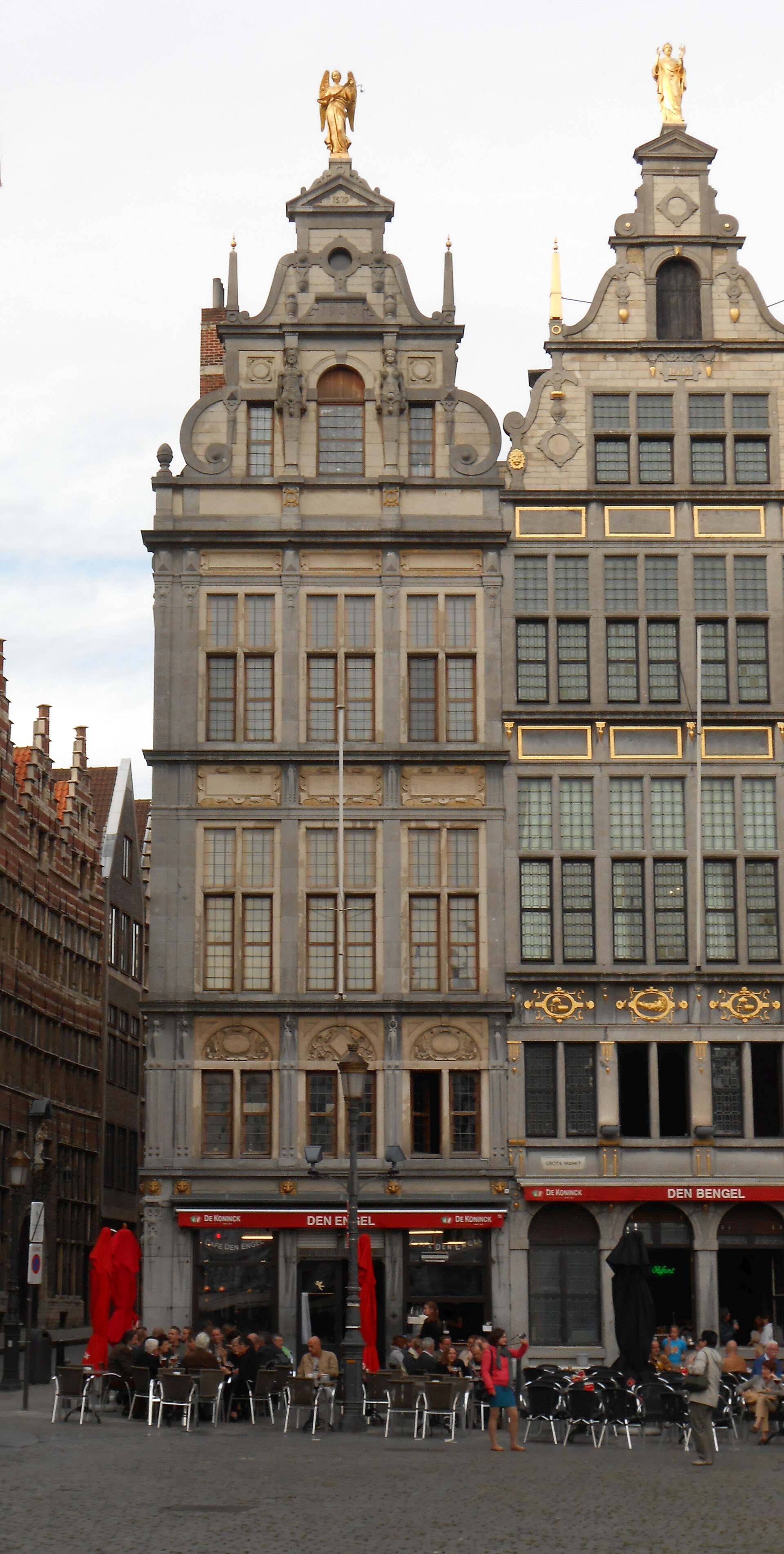 The ornate guild house of café Den Engel on Antwerp's Grote Markt, crowned by a golden angel statue, with a busy terrace below