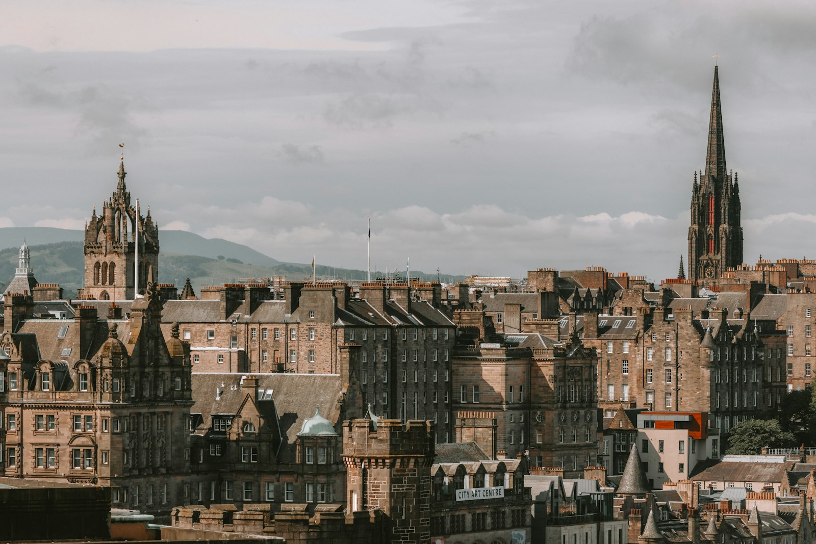 Edinburgh's Old Town rooftops and spires climbing toward the castle on its crag under a moody sky