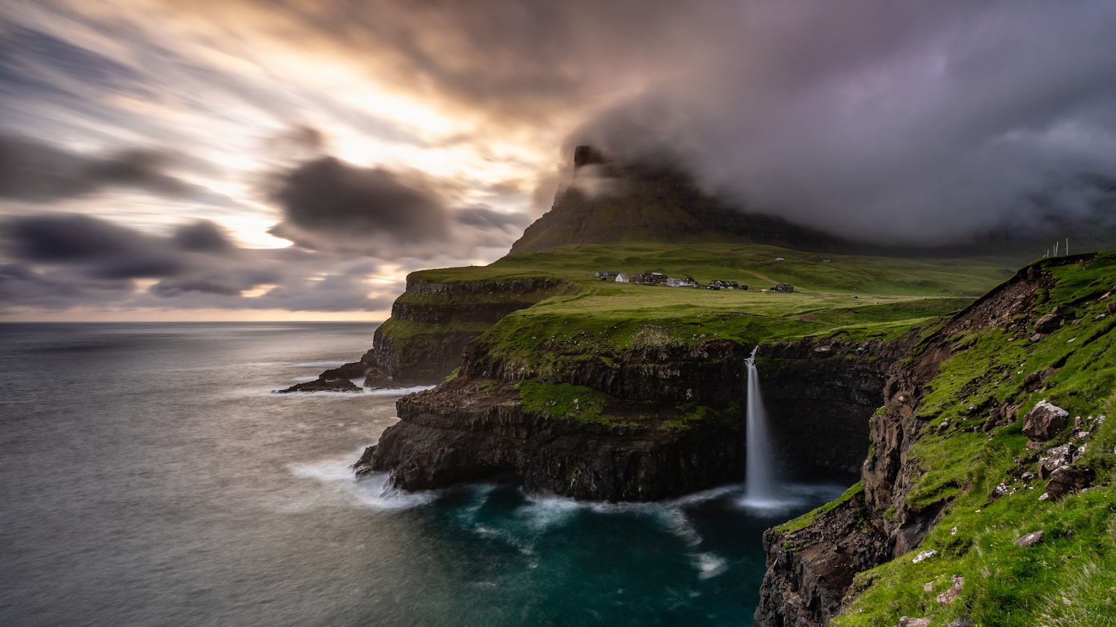 The tiny village of Gásadalur above the Múlafossur waterfall spilling into the sea