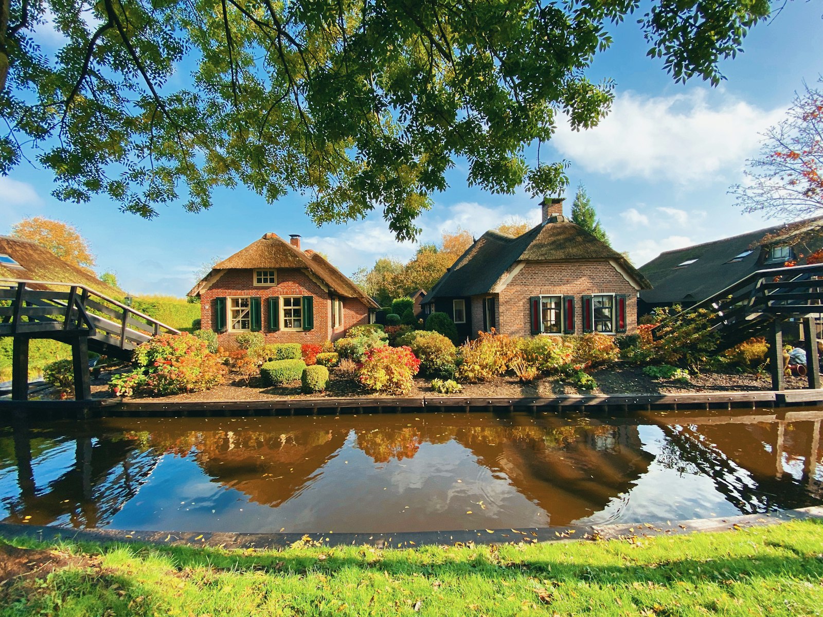 Thatched farmhouses and arched wooden bridges over the canals of Giethoorn