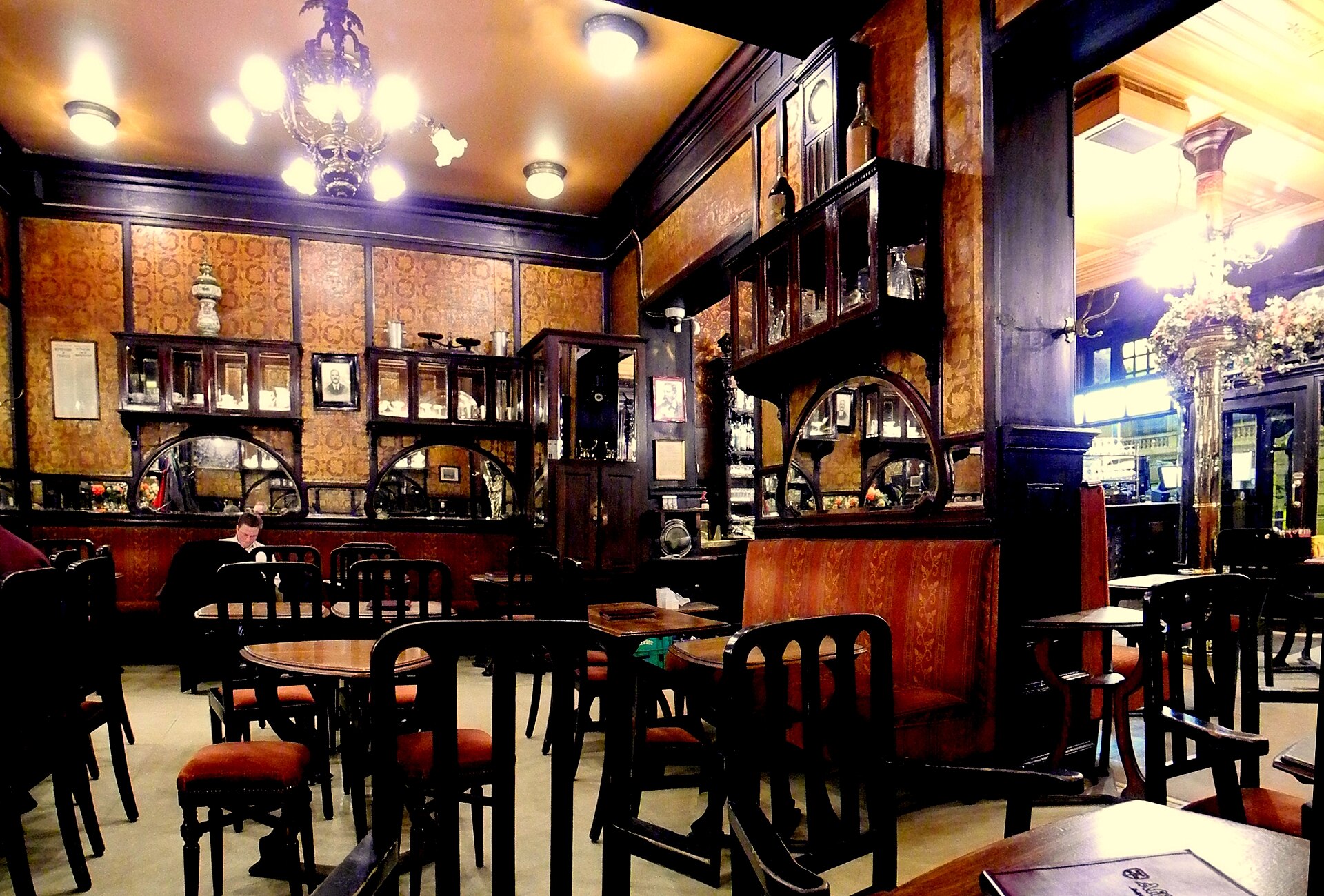 The belle-époque interior of Le Cirio in Brussels, with carved dark wood, gilt walls, art-nouveau mirrors and chandeliers