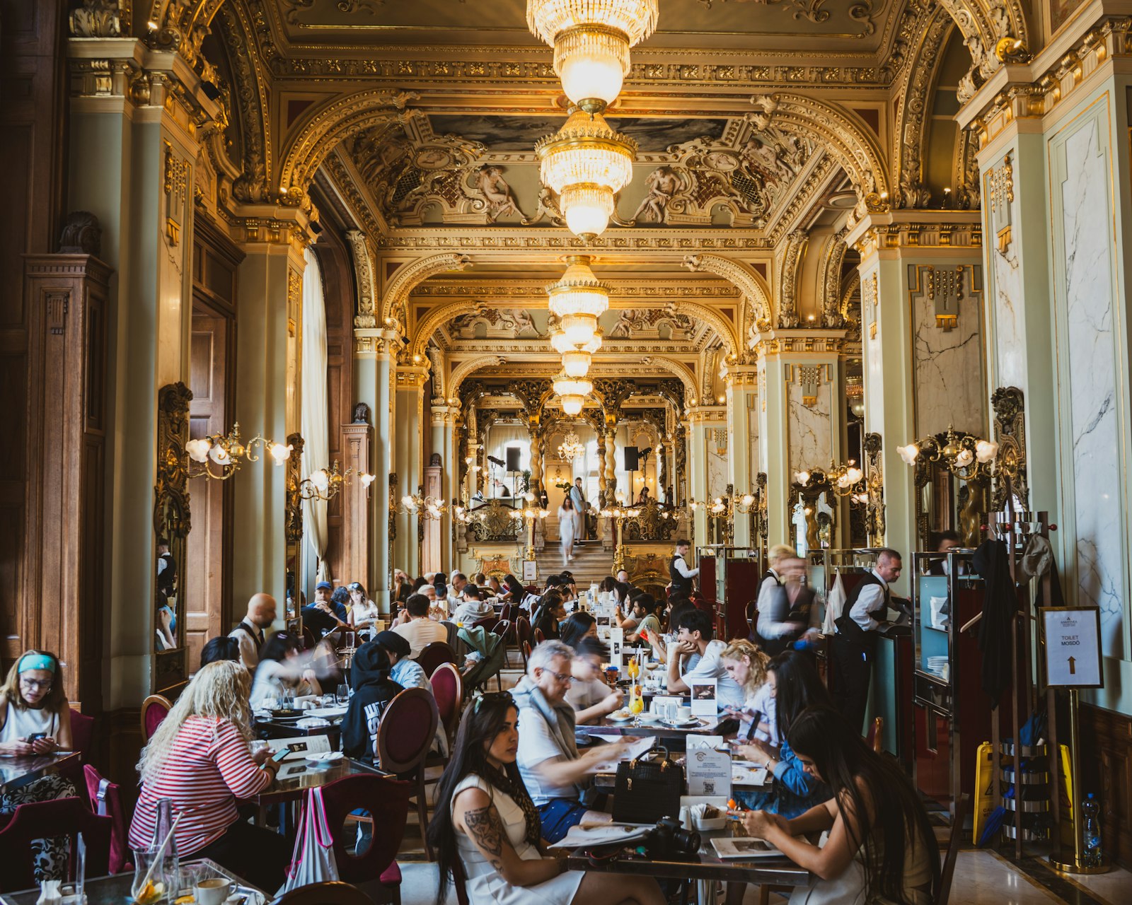 The opulent gilded columns, frescoed ceilings and chandeliers of the New York Café in Budapest