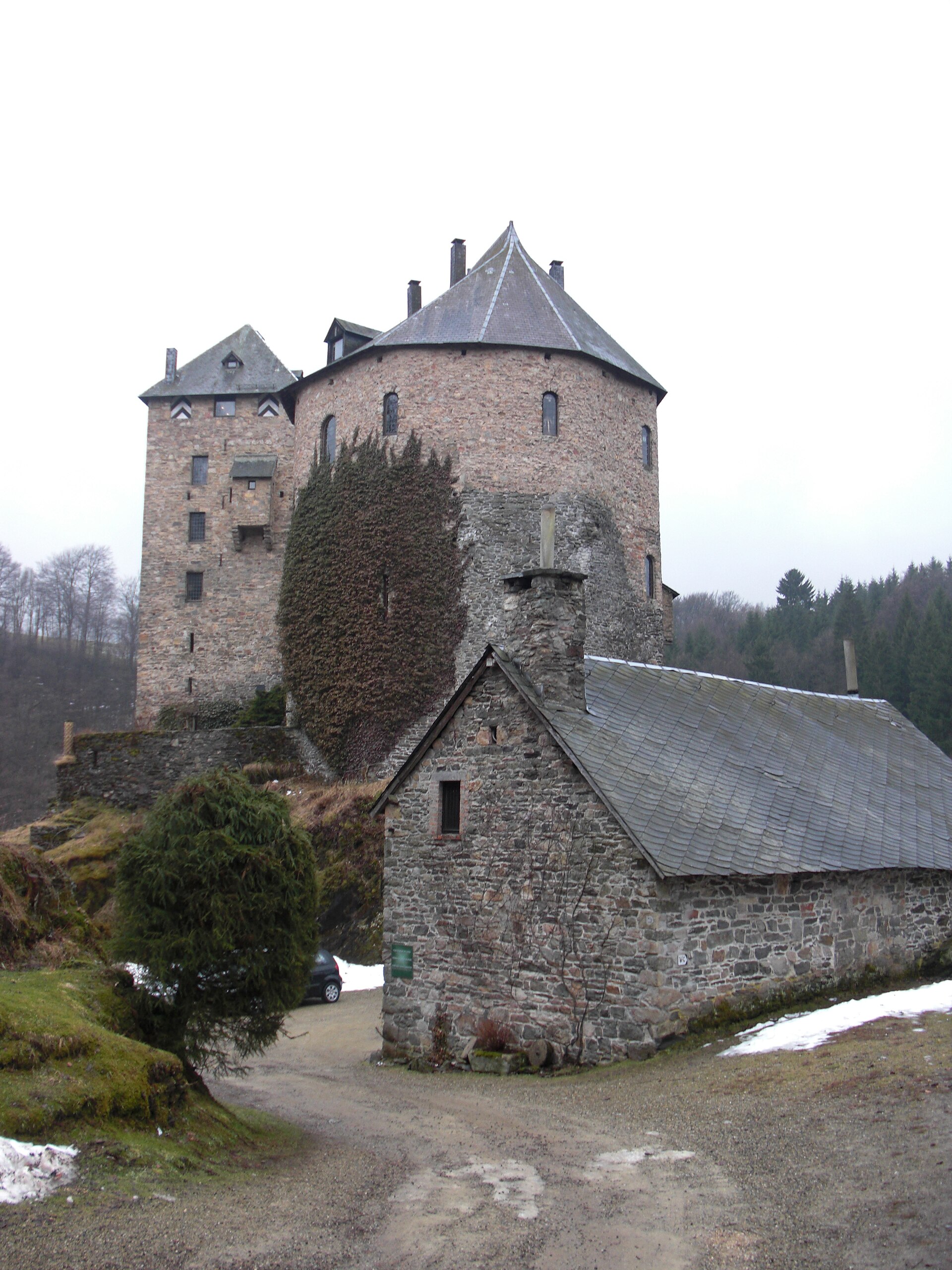 The tall keep of Château de Reinhardstein rising from the forested Warche valley in eastern Belgium