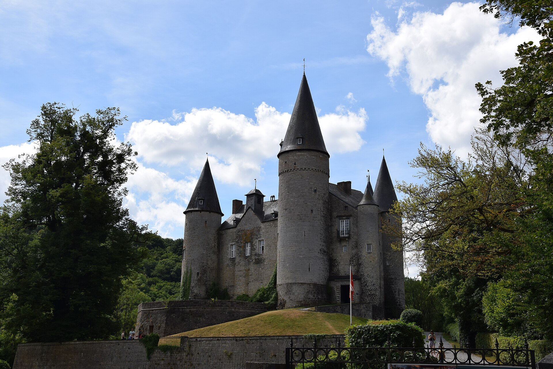 The six pointed towers of Château de Vêves rising on their wooded spur near Dinant